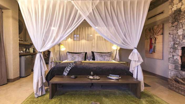 Ein Schlafzimmer mit einem Himmelbett und einer Bank