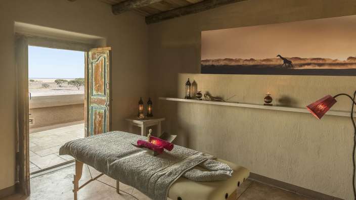 Ein Raum mit einem Massagetisch und einem Gemälde einer Giraffe an der Wand