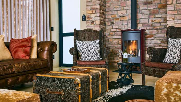 Ein Wohnzimmer mit einer Couch und Stühlen und einem Kamin