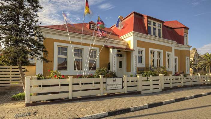 Ein Gebäude mit einem weißen Zaun und einem Schild mit der Aufschrift the charming house