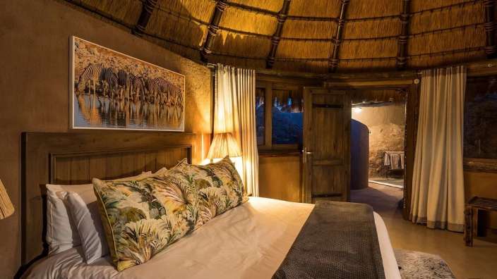 Ein Schlafzimmer mit einem Strohdach und einem Bett