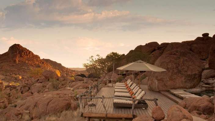 Ein Deck mit Liegestühlen und Sonnenschirmen in der Wüste