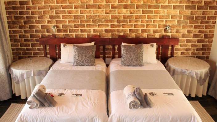 Ein Zimmer mit zwei Betten und einer Backsteinmauer