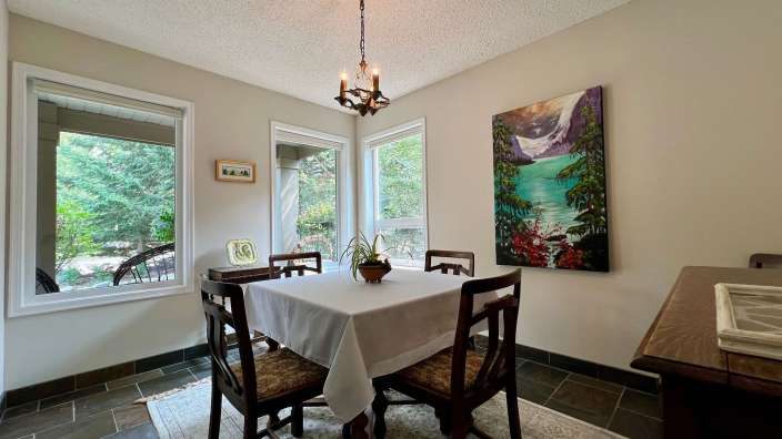 Ein Esszimmer mit einem Tisch und Stühlen und einem Gemälde an der Wand