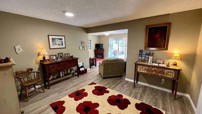 Ein Wohnzimmer mit einem Teppich mit roten Blumen darauf