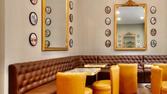 Ein Wohnzimmer mit braunen Ledersofas und gelben Stühlen