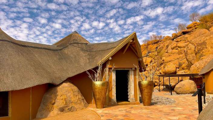 Ein Haus mit Strohdach und goldenen Vasen davor