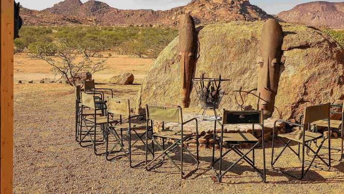 Eine Gruppe von Stühlen steht in einem Kreis vor einem großen Felsen