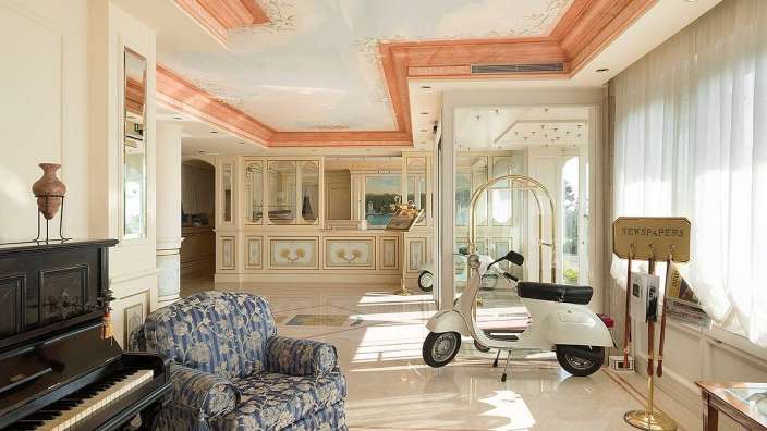 Ein Raum mit einem Klavier, einem Stuhl und einem Zeichen für Zeitungen