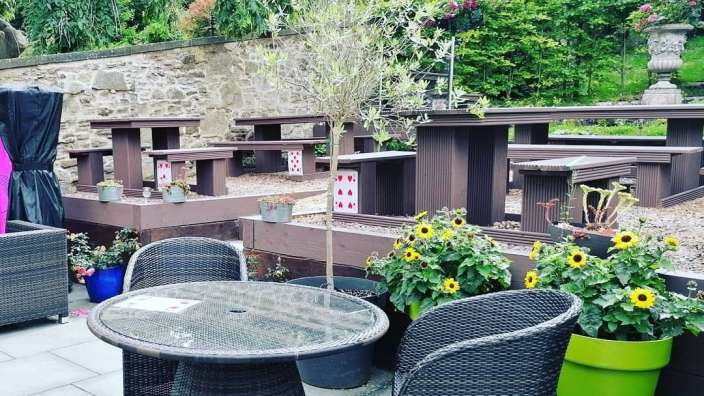 Ein Tisch und Stühle auf einer Terrasse mit Karten auf den Bänken