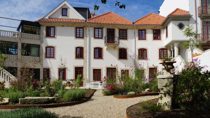 Ein großes weißes Haus mit roten Fenstern und einem roten Dach
