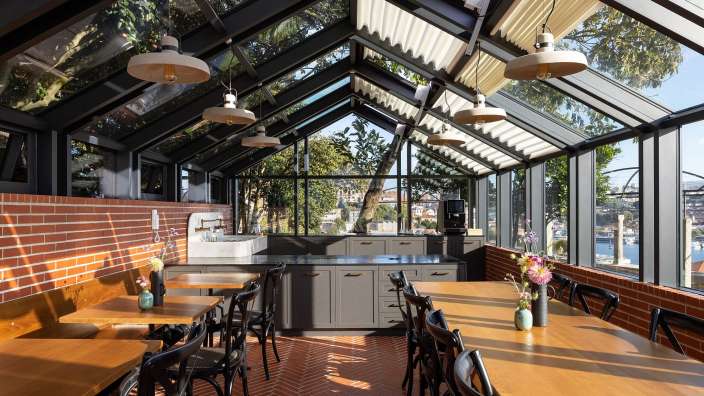 Ein Restaurant mit Tisch und Stühlen und einem großen Glasdach