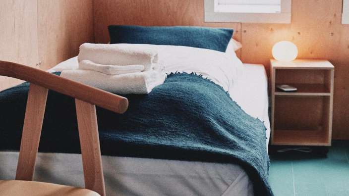 Ein Bett mit blauer Decke und weißen Handtüchern