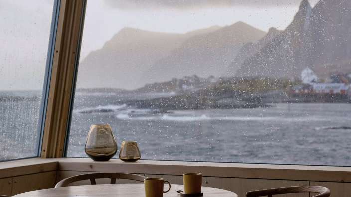 Ein Tisch und Stühle vor einem Fenster mit Blick auf den Ozean