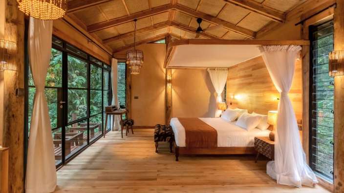 Ein Schlafzimmer mit einem Himmelbett und vielen Fenstern