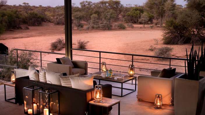 Eine Terrasse mit einer Couch und Stühlen und Laternen