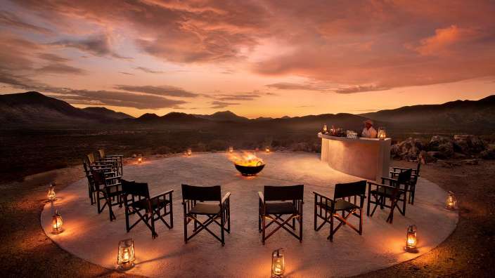 Eine Gruppe von Stühlen steht in einem Kreis um einen Feuerplatz