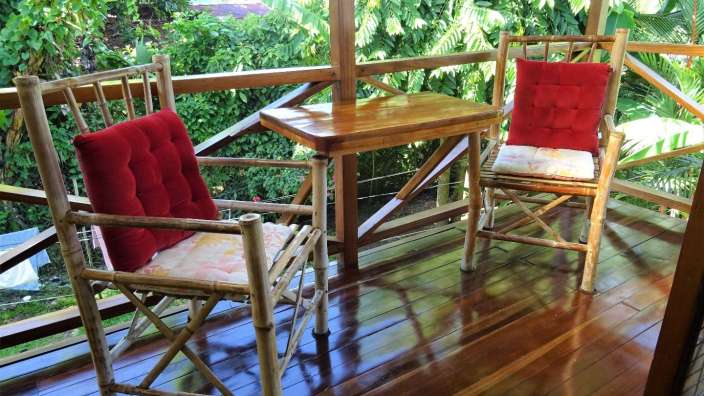 Ein Tisch und zwei Stühle auf einem Holzdeck