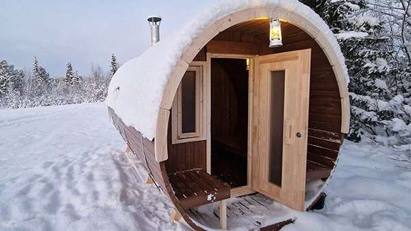 Eine Holzsauna in einem schneebedeckten Feld