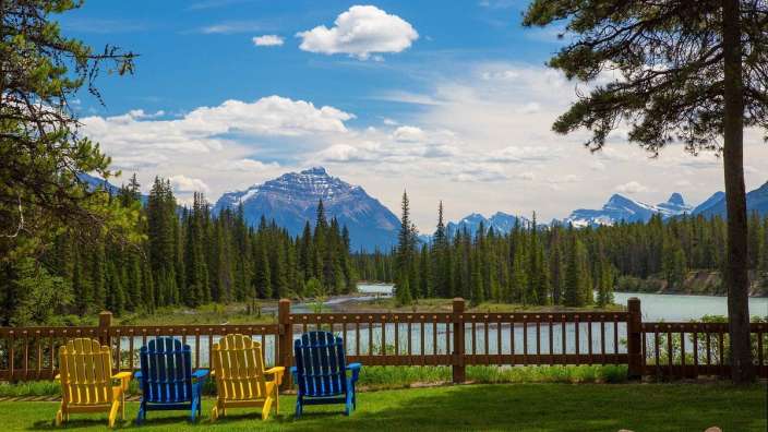 Eine Reihe von Stühlen, die neben einem Holzzaun stehen