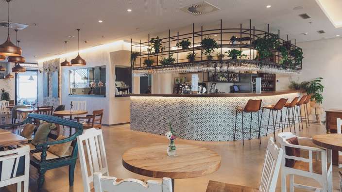 Ein Restaurant mit Holztischen und Stühlen und einer Bar