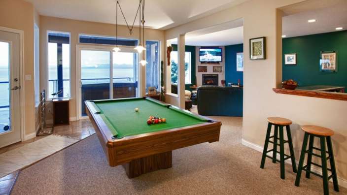 Ein Wohnzimmer mit einem Billardtisch und einem Fernseher