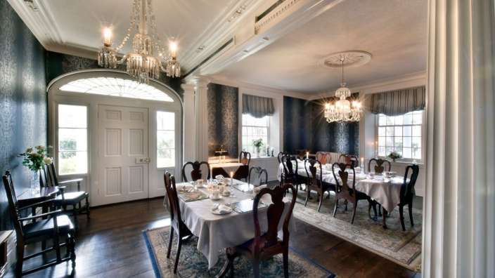 Ein Esszimmer mit einem Tisch und Stühlen und einem Kronleuchter