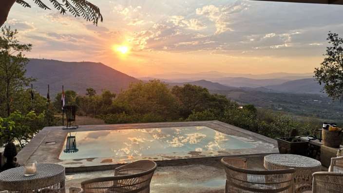 Ein Swimmingpool mit Blick auf die Berge bei Sonnenuntergang