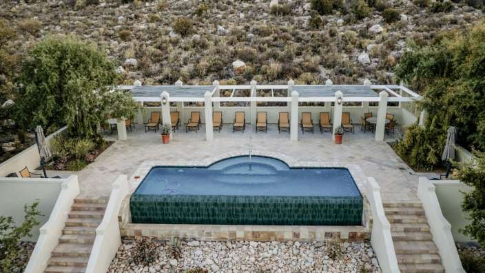 Ein großer Pool mit vielen Stühlen und Treppen davor
