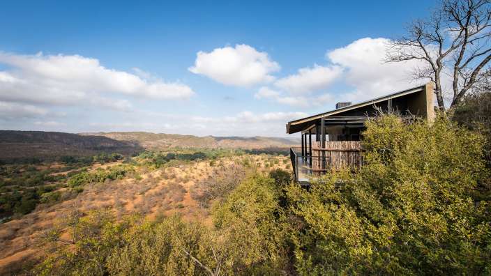 Ein Haus auf einem Hügel mit Blick auf die Berge