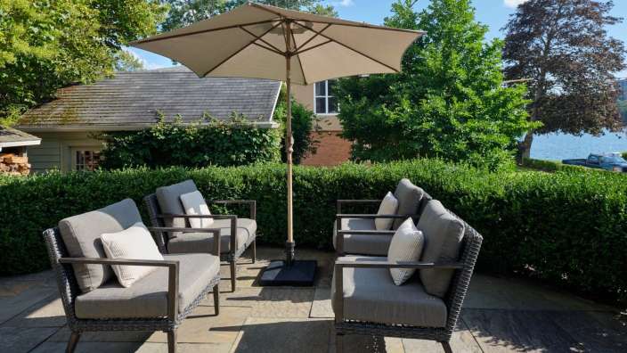 Eine Terrasse mit Möbeln und einem großen Sonnenschirm