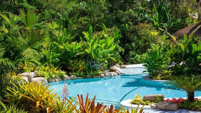 Ein großer Swimmingpool inmitten eines tropischen Gartens