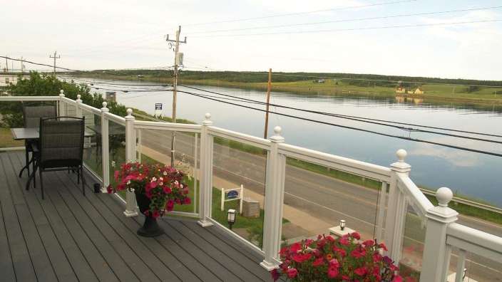 Ein Deck mit einem Tisch und Stühlen und einem Wasserblick