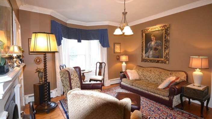 Ein Wohnzimmer mit einem Gemälde einer Frau an der Wand