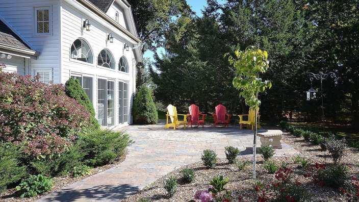 Eine Terrasse mit roten und gelben Stühlen vor einem weißen Haus