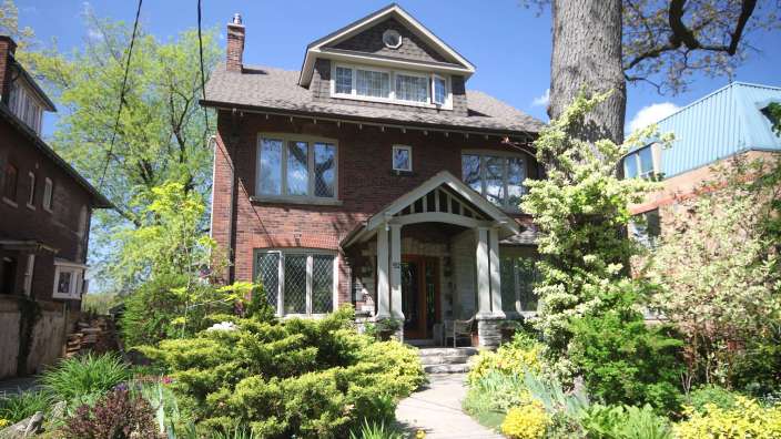 Ein großes Backsteinhaus mit einem großen Baum davor