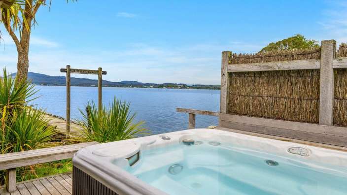 Ein Whirlpool steht auf einem Holzdeck mit Blick auf einen See