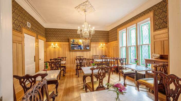 Ein Esszimmer mit Tischen und Stühlen und einem Kronleuchter