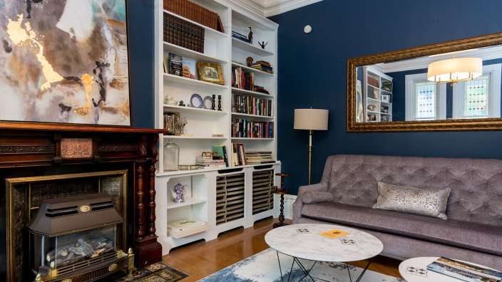 Ein Wohnzimmer mit Couch , Kamin und Bücherregalen