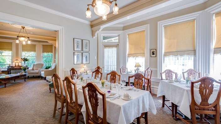 Ein Esszimmer mit Tischen und Stühlen und einem Kronleuchter