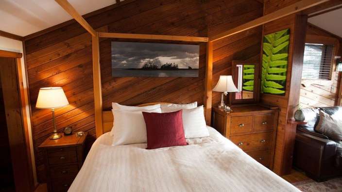 Ein Schlafzimmer mit einem Himmelbett und einem Gemälde an der Wand