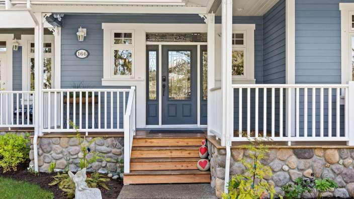 Die Vorderseite eines blauen Hauses mit der Hausnummer 168