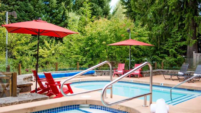 Ein schwimmbad mit roten sonnenschirmen und roten stühlen