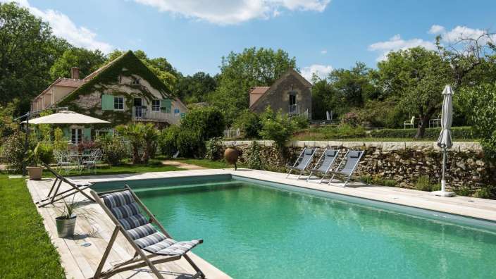 Liegestühle und Sonnenschirme um einen großen Swimmingpool