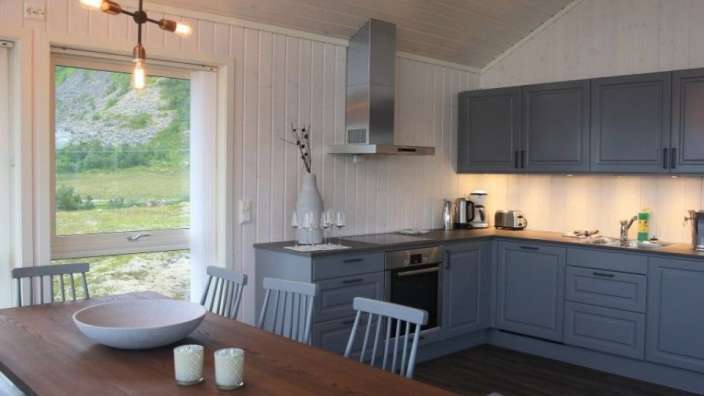 Eine Küche mit grauen Schränken und einem Esstisch