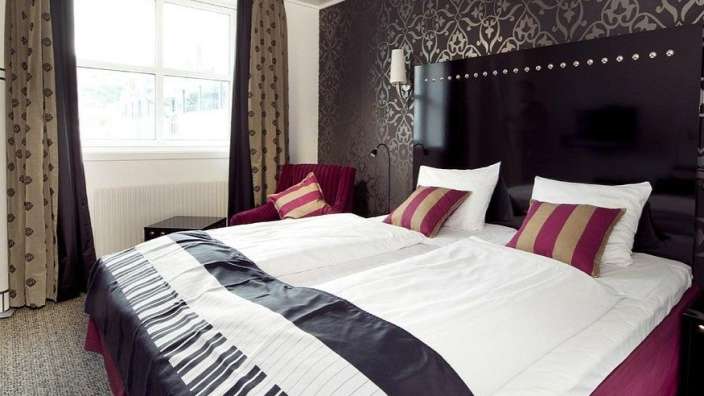 Ein Hotelzimmer mit zwei Betten und einem Stuhl