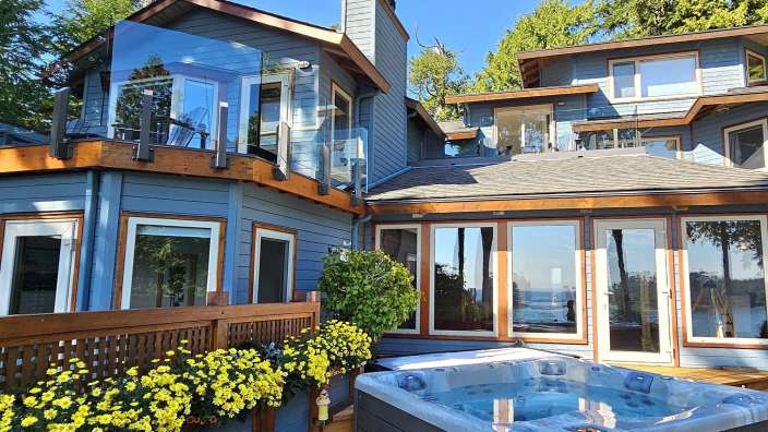Ein großes Haus mit vielen Fenstern und einer Jacuzzi im Vordergrund