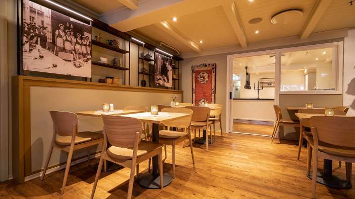 Ein Esszimmer mit Tischen und Stühlen und einem Gemälde an der Wand