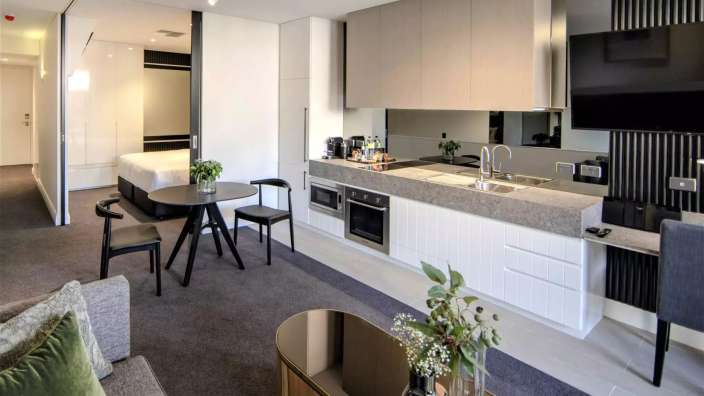 Ein Wohnzimmer mit einem Tisch und Stühlen neben einer Küche