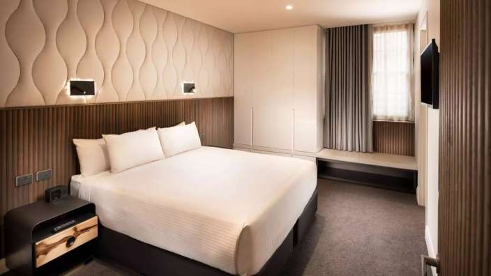 Ein Hotelzimmer mit einem Bett und einem Nachttisch